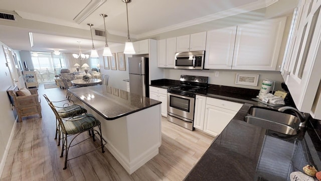 kitchen featuring a center island, stainless steel appliances, sink, white cabinets, and light hardwood / wood-style flooring