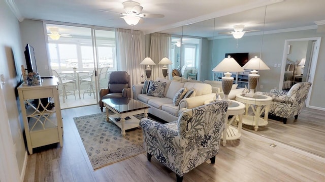 living room with hardwood / wood-style floors, ceiling fan, and crown molding