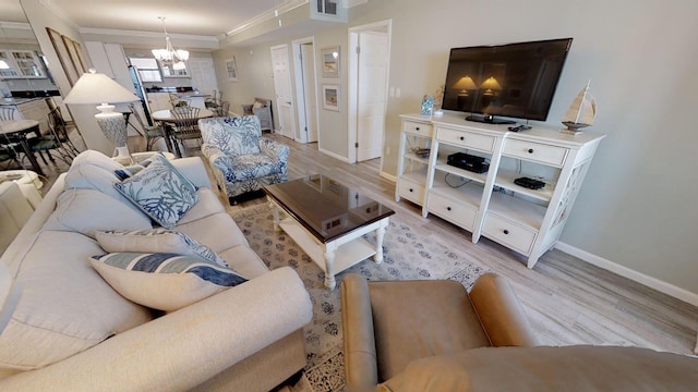 living room featuring light hardwood / wood-style floors, an inviting chandelier, and ornamental molding