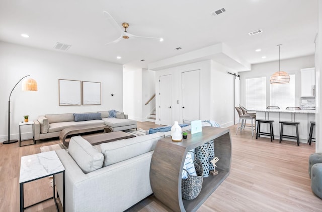 living room with ceiling fan and light hardwood / wood-style flooring