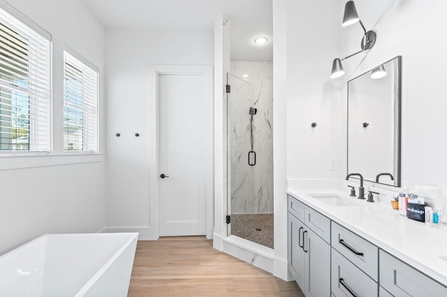 bathroom with vanity, shower with separate bathtub, and hardwood / wood-style floors