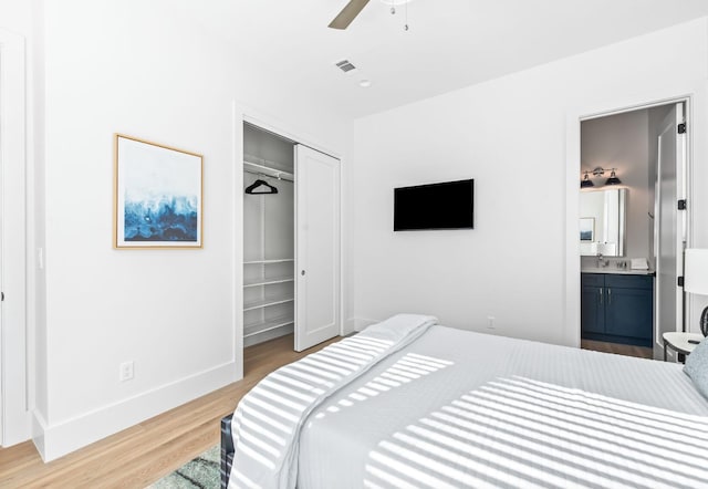 bedroom featuring ceiling fan, connected bathroom, a closet, and light wood-type flooring