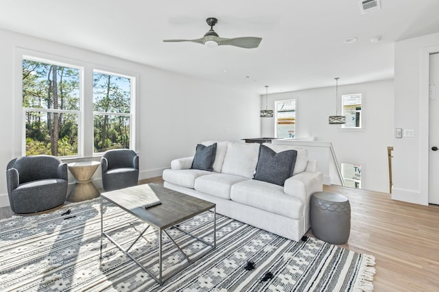 living room with light wood-type flooring and ceiling fan