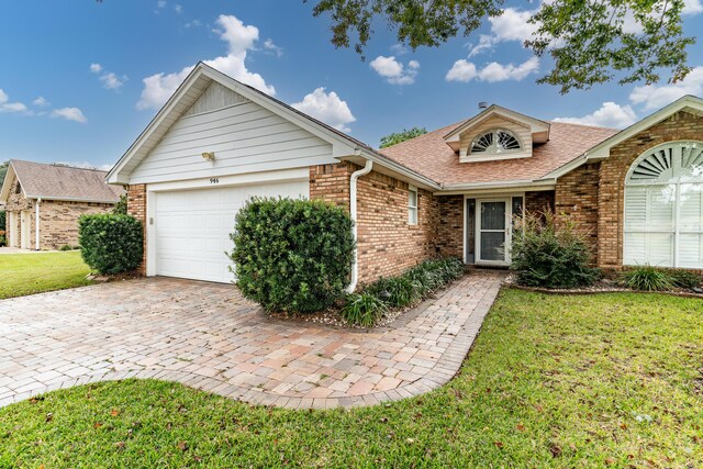 946 Shalimar Point Dr, Shalimar, FL 32579 - ranch-style house with brick siding, an attached garage, a front lawn, roof with shingles, and driveway