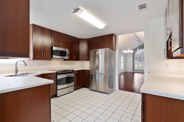 946 Shalimar Point Dr, Shalimar, FL 32579 - kitchen with appliances with stainless steel finishes, a sink, a chandelier, light countertops, and a textured ceiling