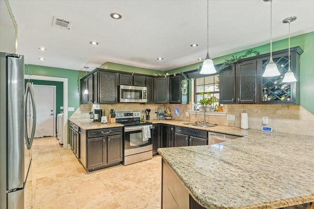 kitchen with sink, stainless steel appliances, backsplash, pendant lighting, and dark brown cabinets