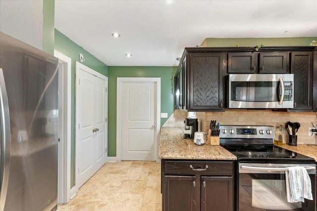 kitchen with light stone countertops, dark brown cabinetry, backsplash, and appliances with stainless steel finishes