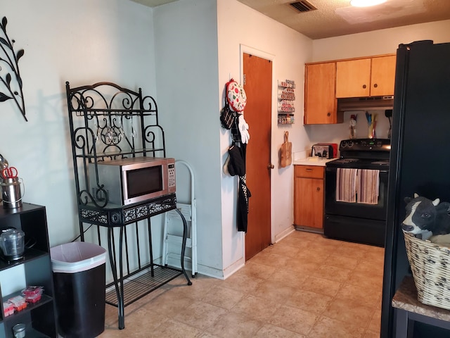 50 Junior Dr, Shalimar, FL 32579 - kitchen featuring black appliances, under cabinet range hood, light countertops, and baseboards