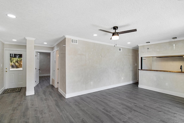 unfurnished living room featuring crown molding, ceiling fan, dark wood-type flooring, and a textured ceiling