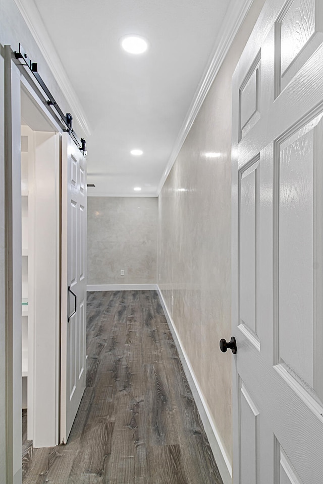 hall with dark hardwood / wood-style flooring, a barn door, and crown molding