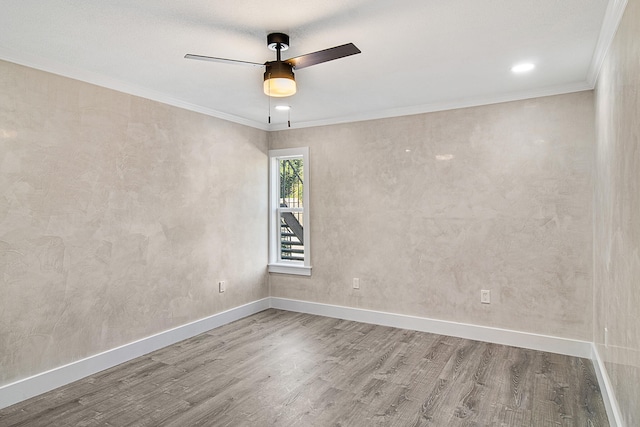 empty room with crown molding, hardwood / wood-style floors, and ceiling fan