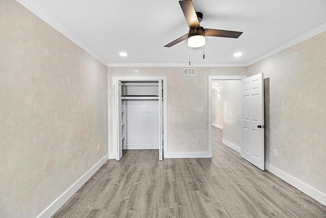 402 Marshall Ct Unit 01, Fort Walton Beach, FL 32548 - unfurnished bedroom featuring wood finished floors, crown molding, baseboards, a closet, and ceiling fan