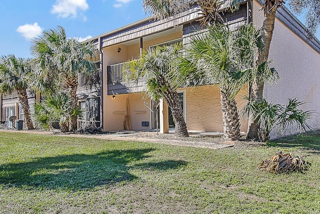 402 Marshall Ct Unit 01, Fort Walton Beach, FL 32548 - back of house with stucco siding, a yard, and a balcony