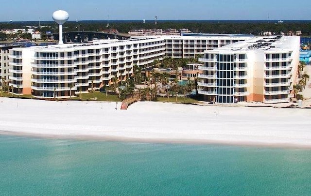 view of building exterior with a water view and a view of the beach