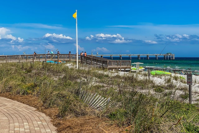 surrounding community with a water view and a pier