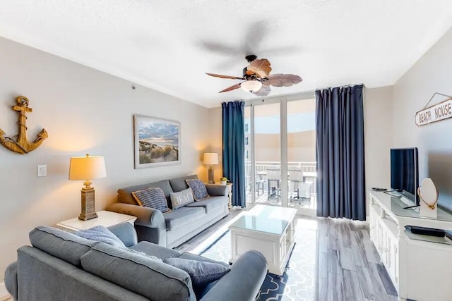 living room with light hardwood / wood-style floors, ceiling fan, and floor to ceiling windows