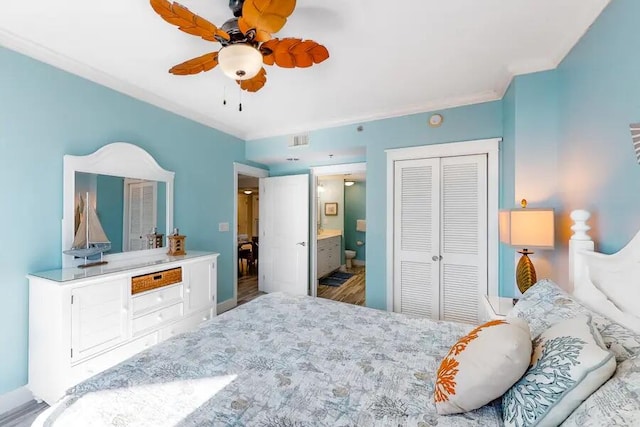 bedroom featuring hardwood / wood-style flooring, ornamental molding, ceiling fan, connected bathroom, and a closet