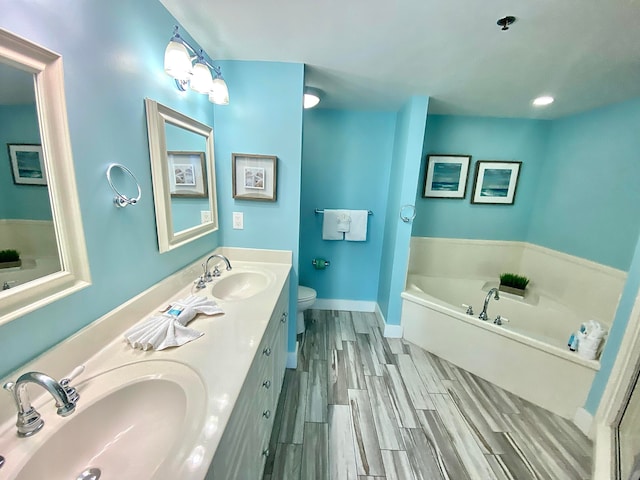 bathroom with hardwood / wood-style floors, a bath, toilet, and vanity