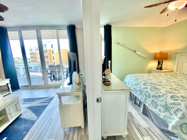 bedroom with access to outside, ceiling fan, crown molding, light wood-type flooring, and a wall of windows