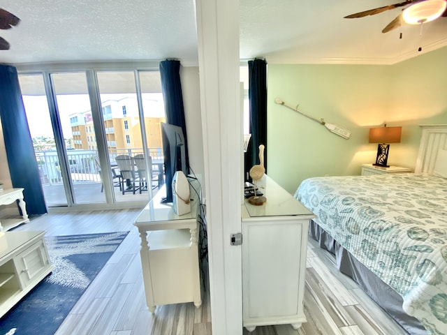 bedroom with access to outside, light wood finished floors, ornamental molding, a textured ceiling, and a ceiling fan