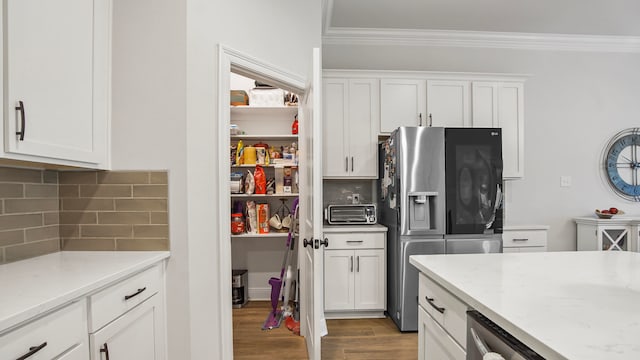 kitchen featuring white cabinets, stainless steel fridge, tasteful backsplash, and light hardwood / wood-style floors