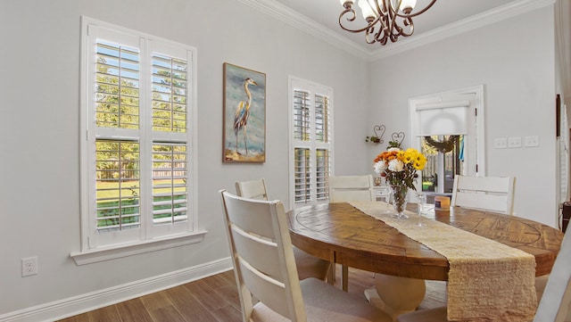 dining room with hardwood / wood-style floors, ornamental molding, and a chandelier