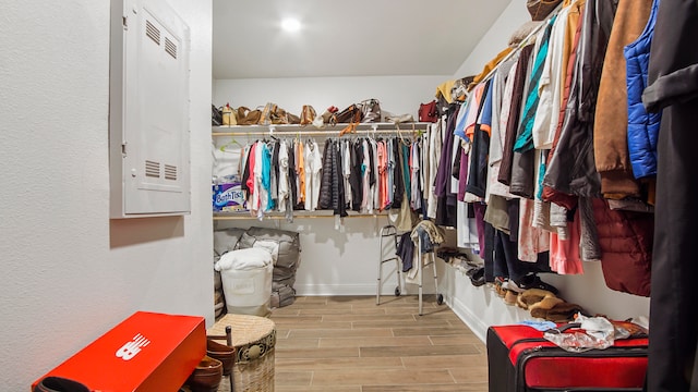 spacious closet featuring electric panel and light hardwood / wood-style flooring