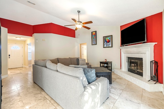 living room with a brick fireplace, ceiling fan, and lofted ceiling