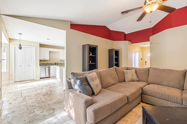 living room with a textured ceiling, high vaulted ceiling, ceiling fan, and sink