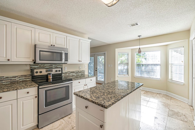 kitchen with white cabinets, backsplash, and appliances with stainless steel finishes