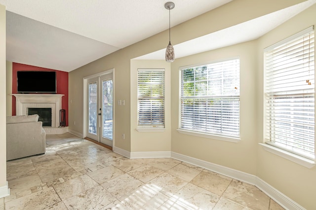 unfurnished dining area featuring lofted ceiling, french doors, and a textured ceiling