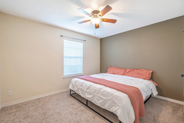 bedroom featuring a textured ceiling, ceiling fan, and light carpet