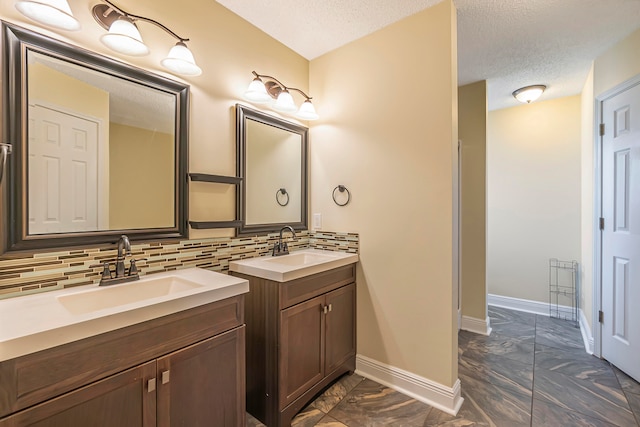 bathroom featuring backsplash, vanity, and a textured ceiling