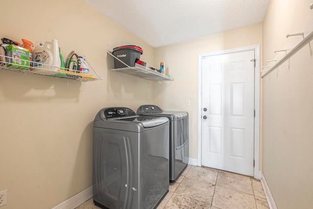 clothes washing area featuring a textured ceiling and washing machine and dryer