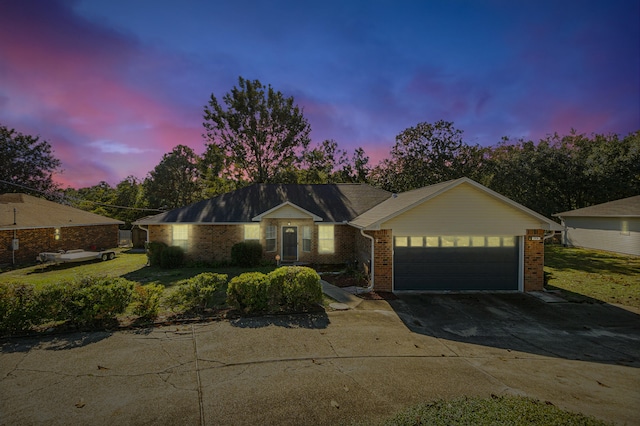 single story home with a garage and a yard