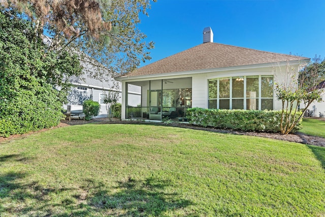 rear view of house with a sunroom and a yard