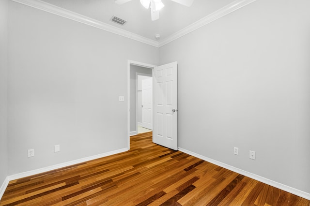 spare room featuring hardwood / wood-style floors, ceiling fan, and crown molding