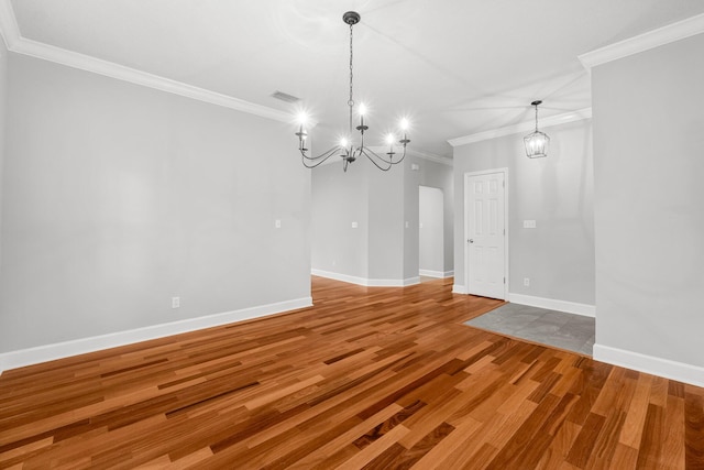 unfurnished dining area with hardwood / wood-style floors, an inviting chandelier, and ornamental molding