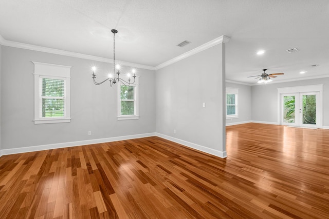 empty room featuring ceiling fan with notable chandelier, wood-type flooring, and ornamental molding