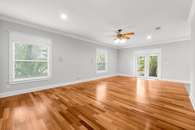 empty room featuring ceiling fan, ornamental molding, a textured ceiling, and light hardwood / wood-style flooring