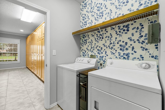 laundry room with a textured ceiling, light tile patterned floors, crown molding, and washing machine and clothes dryer