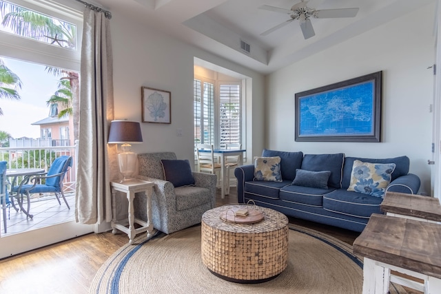 living room featuring wood-type flooring and ceiling fan