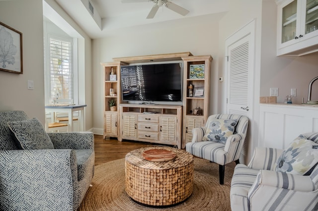 living room with dark hardwood / wood-style flooring and ceiling fan