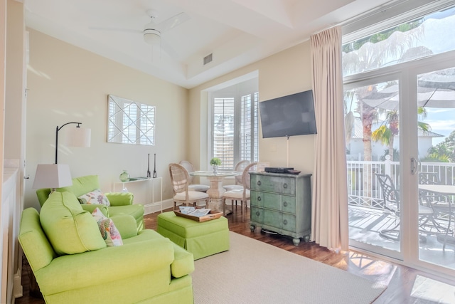 living area with plenty of natural light, dark hardwood / wood-style floors, and ceiling fan