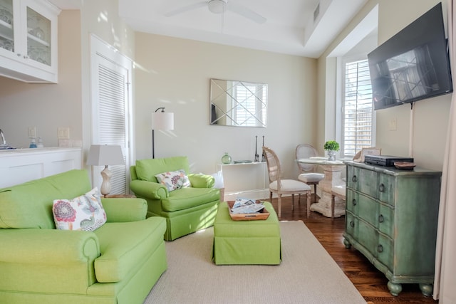 living room with ceiling fan and dark wood-type flooring