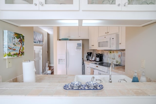 kitchen featuring white cabinets, white appliances, and backsplash