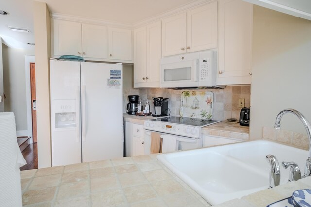 kitchen featuring white cabinets, white appliances, tile counters, and sink