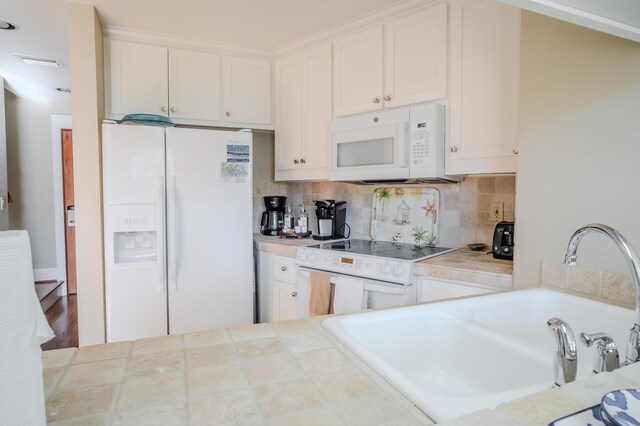 105 Carillon Market St Ste 302, Panama City Beach, FL 32413 - kitchen with white appliances, tile countertops, a sink, white cabinetry, and decorative backsplash