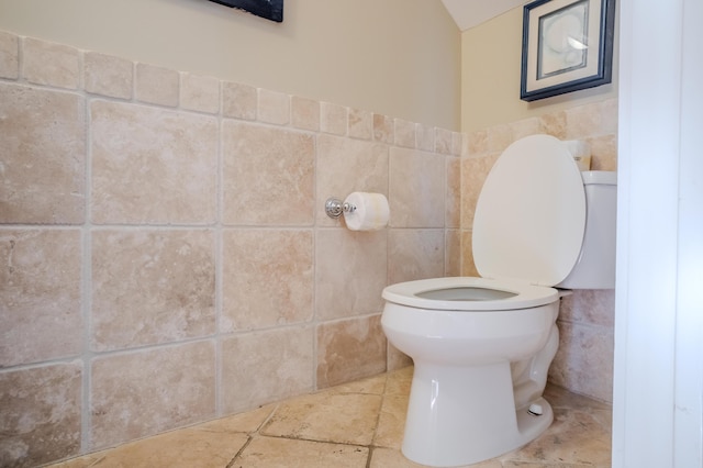 bathroom featuring toilet and tile walls