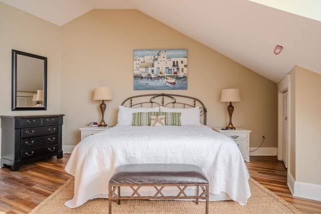105 Carillon Market St Ste 302, Panama City Beach, FL 32413 - bedroom with wood finished floors, vaulted ceiling, and baseboards
